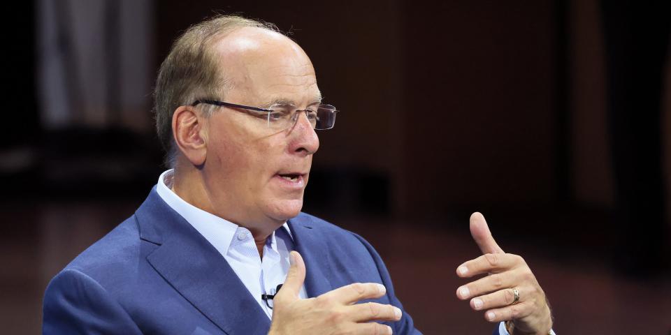 BlackRock CEO Larry Fink gesturing while wearing glasses and a suit jacket.