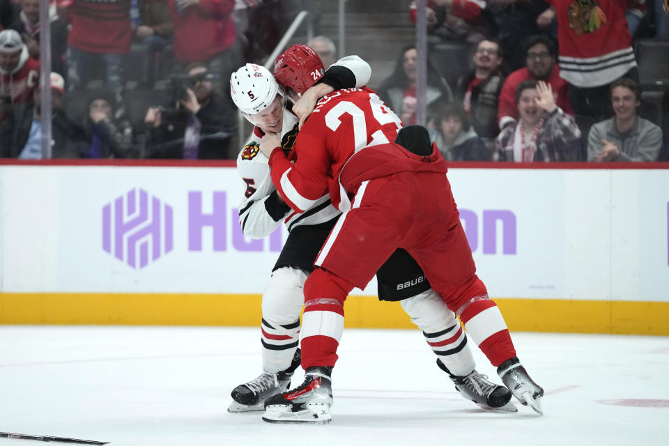 Chicago Blackhawks defenseman Connor Murphy (5) and Detroit Red Wings center Klim Kostin (24) fight in the second period of an NHL hockey game Thursday, Nov. 30, 2023, in Detroit. (AP Photo/Paul Sancya)