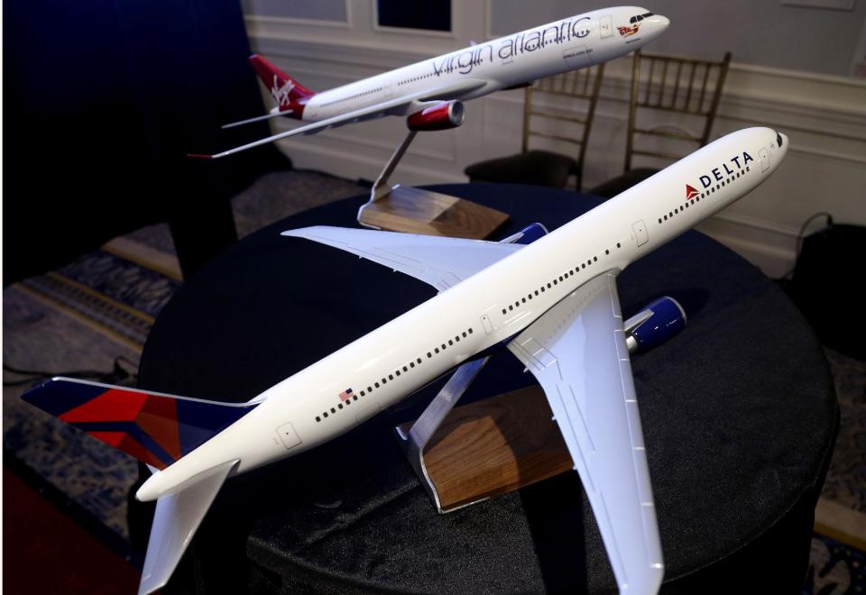 Model planes bearing the logos of Delta Airlines and Virgin Atlantic are displayed during a news conference in New York, Tuesday, Dec. 11, 2012. Delta Air Lines said it will buy almost half of Virgin Atlantic for $360 million as it tries to catch up to rivals in the lucrative New York-to-London travel market. (AP Photo/Seth Wenig)