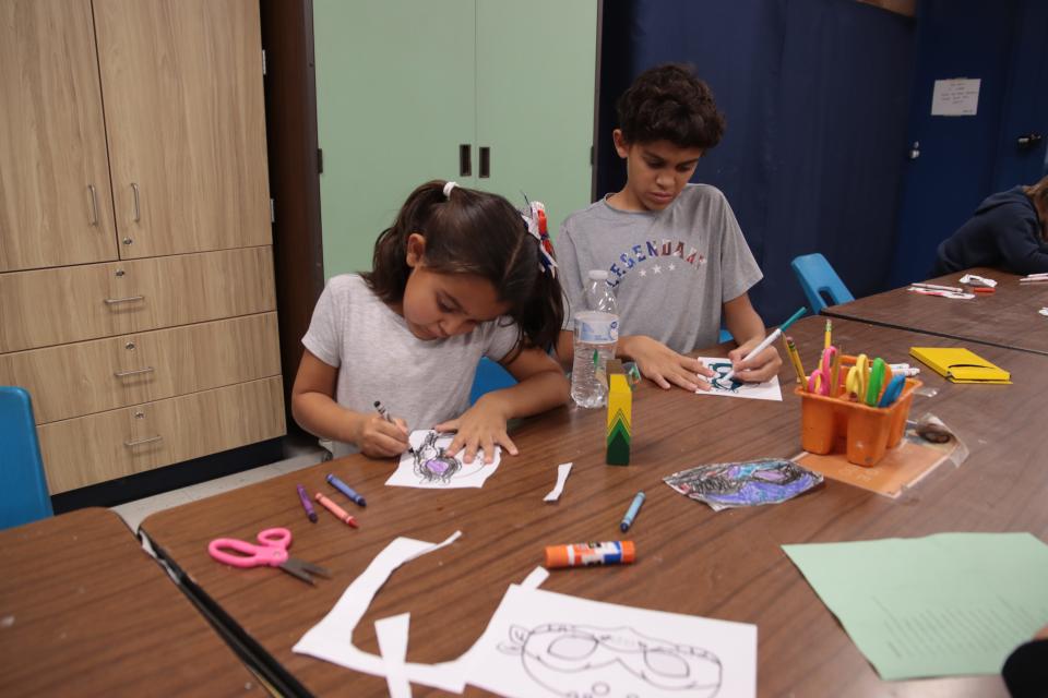 Stella Rosales, an Alexander Elementary School kindergartener, and sixth grader Chase Rosales, color Nov. 11, 2022, during the Animal Kingdom of Kindness fall festival at the school.