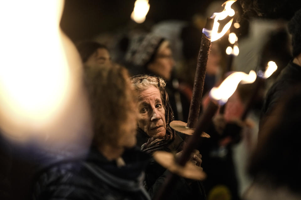 People hold torches as they demand the immediate release of the Israeli hostages held in the Gaza Strip by the Hamas militant group, in Jerusalem, Monday, Feb. 19, 2024. (AP Photo/Leo Correa)