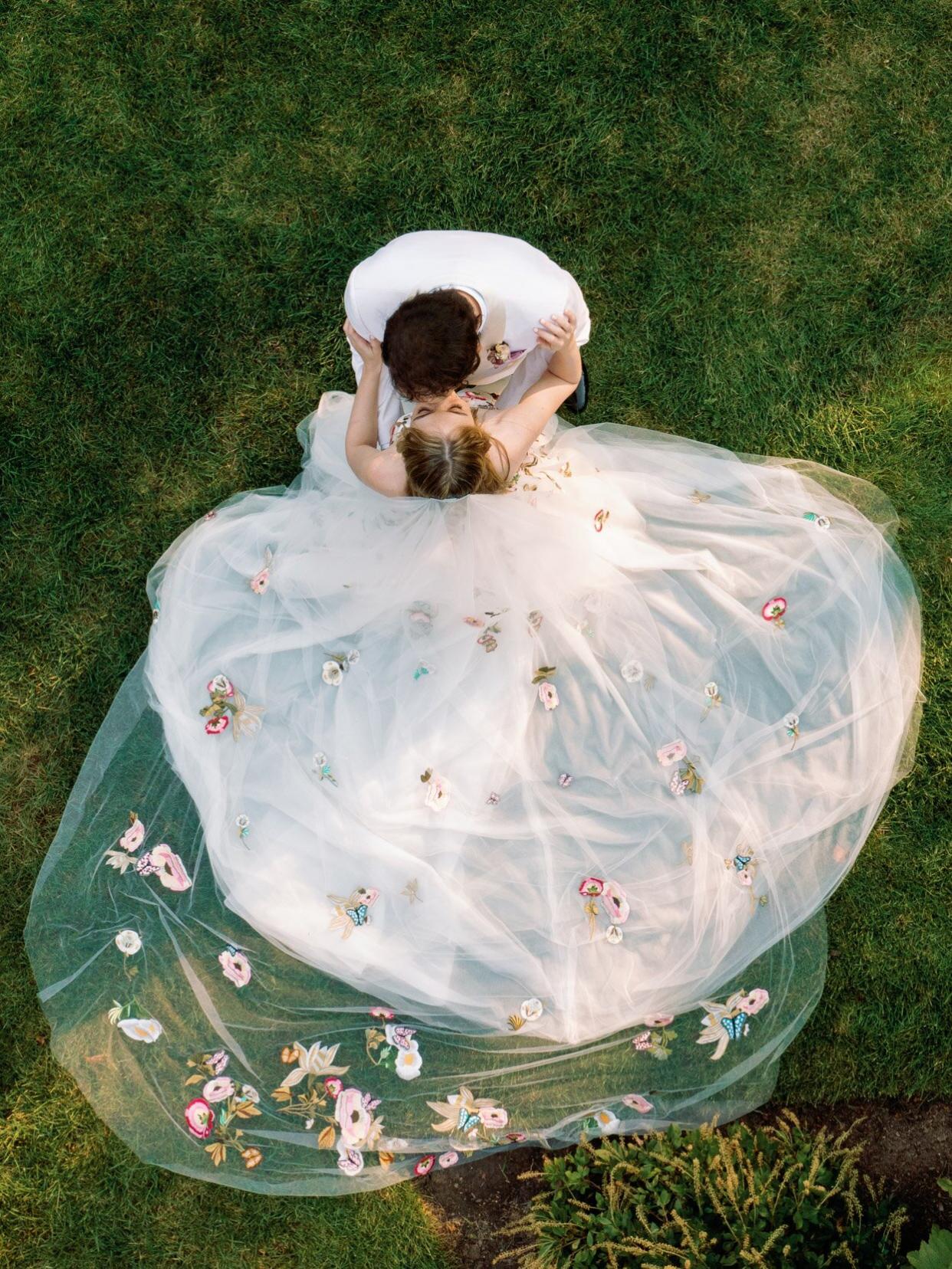 bride and groom kissing with wedding veil spread out behind