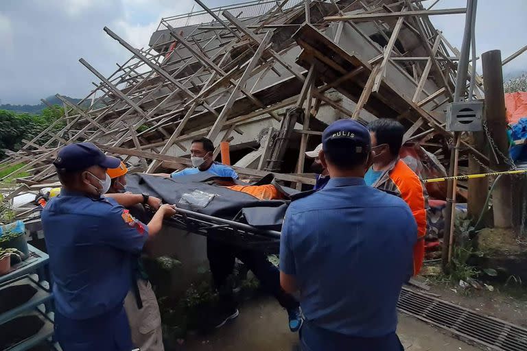 Esta foto tomada de la página de Facebook de la Comisaría Municipal de La Trinidad muestra a un equipo de rescate trasladando el cuerpo de un trabajador de la construcción en el lugar donde se derrumbó un edificio en La Trinidad, en la provincia de Benguet, el 27 de julio de 2022