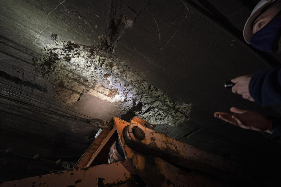 A disintegrating ceiling is illuminated by Amtrak workers as they perform tunnel repairs to a partially flooded train track bed, Saturday, March 20, 2021, in Weehawken, N.J. With a new rail tunnel into New York years away at best, Amtrak is embarking on an aggressive and expensive program to fix a 110-year-old tunnel in the interim. (AP Photo/John Minchillo)