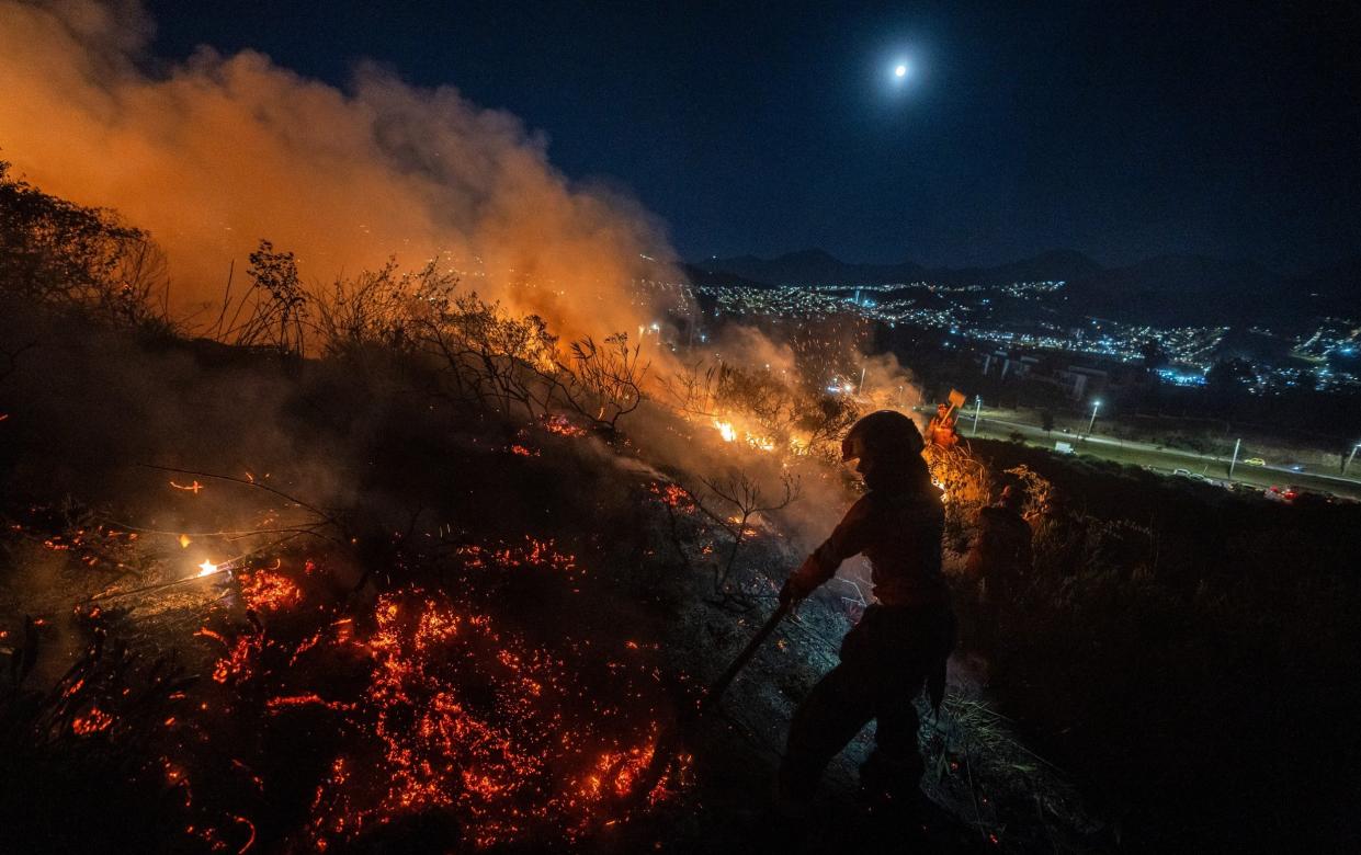 Fire crews try to extinguish flames in forests in Bogota