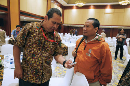 Former Indonesian militant Toni Togar (R) talks with Sarinah Jakarta bomb victims Denny Mahieu during a meeting between former militants and victims in Jakarta, Indonesia, February 28, 2018. REUTERS/Beawiharta