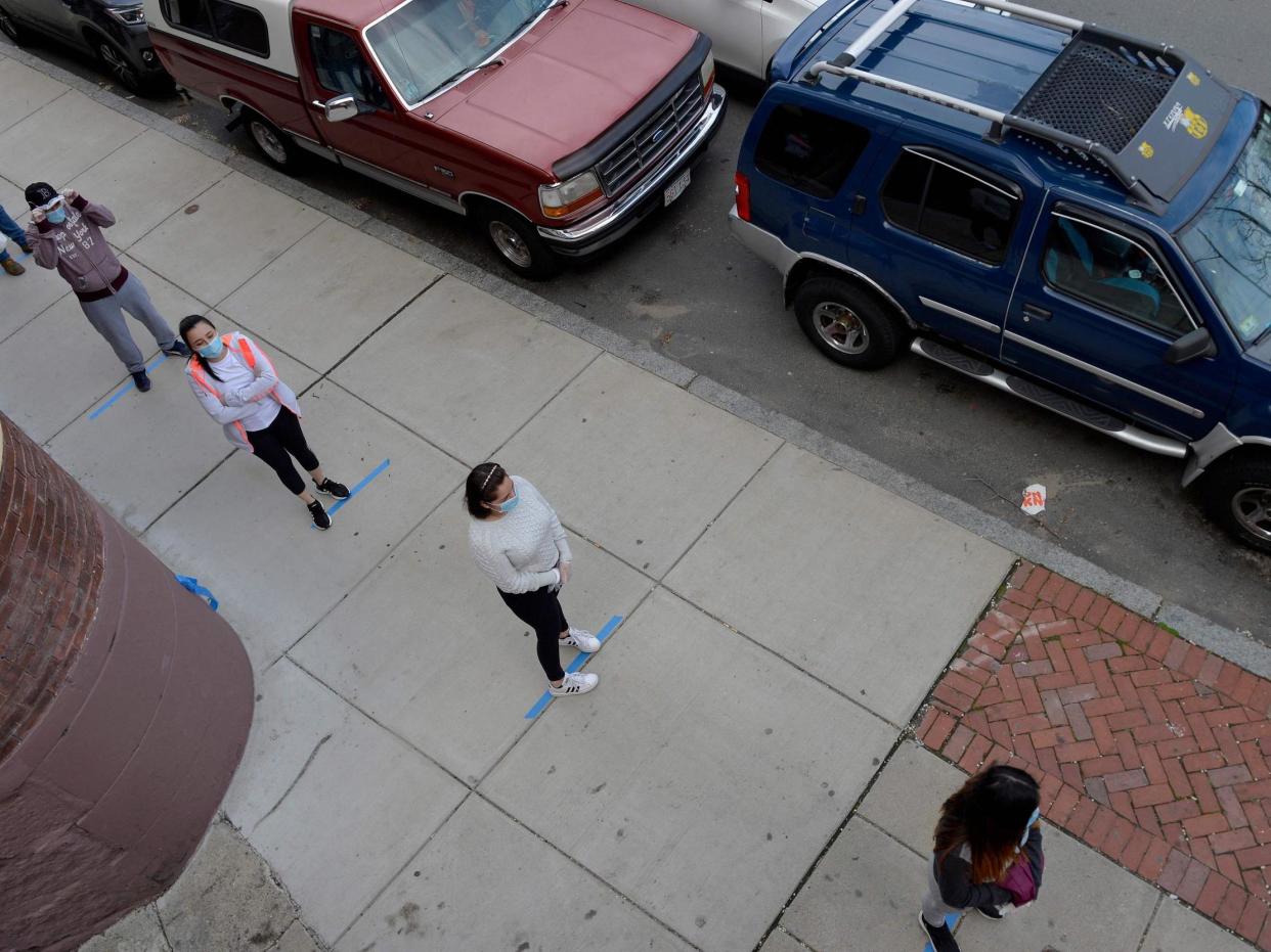 People adhere to social distancing guidelines while lining up to receive food and goods in Chelsea, Massachusetts on 14 April, 2020: JOSEPH PREZIOSO/AFP via Getty Images