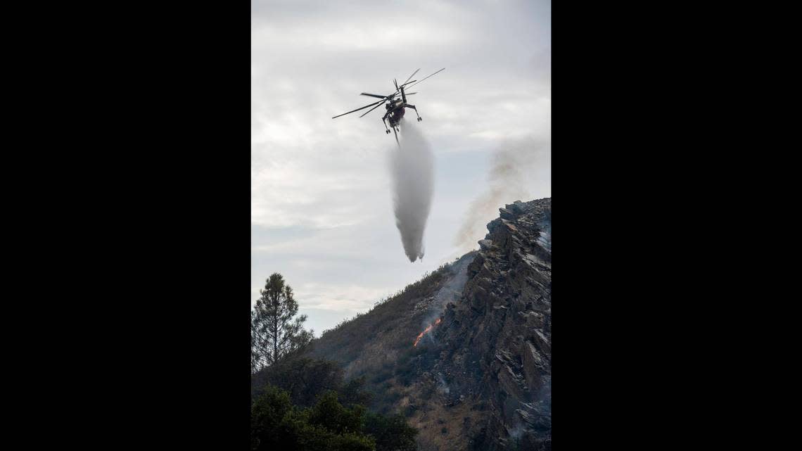 A helicopter is shown dropping flame retardant on the Agua Fire near Mariposa on July 18, 2022.