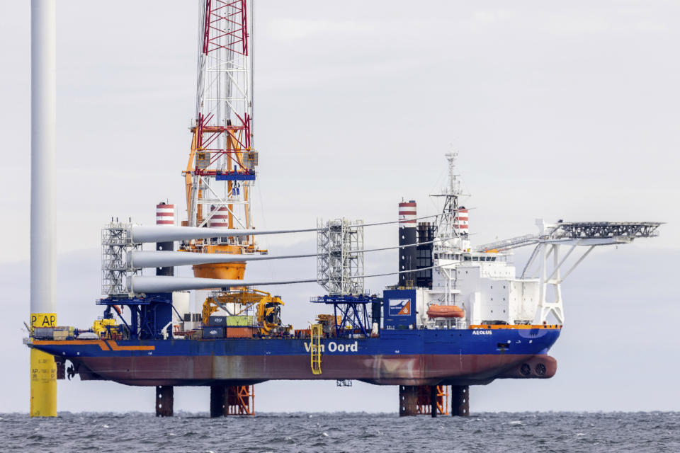 FILE - A barge carries blades for the third turbine at the South Fork Wind farm, Dec. 7, 2023, east of Montauk Point, N.Y. Unfounded claims about offshore wind threatening whales have surfaced as a flashpoint in the fight over the future of renewable energy. (AP Photo/Julia Nikhinson, File)