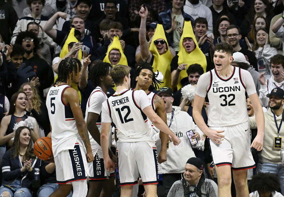 UConn guard Cam Spencer (12) chest bumps teammate UConn guard Solomon Ball after Ball made a basket with a foul in the first half of an NCAA college basketball game against Arkansas-Pine Bluff, Saturday, Dec. 9, 2023, in Storrs, Conn. (AP Photo/Jessica Hill)