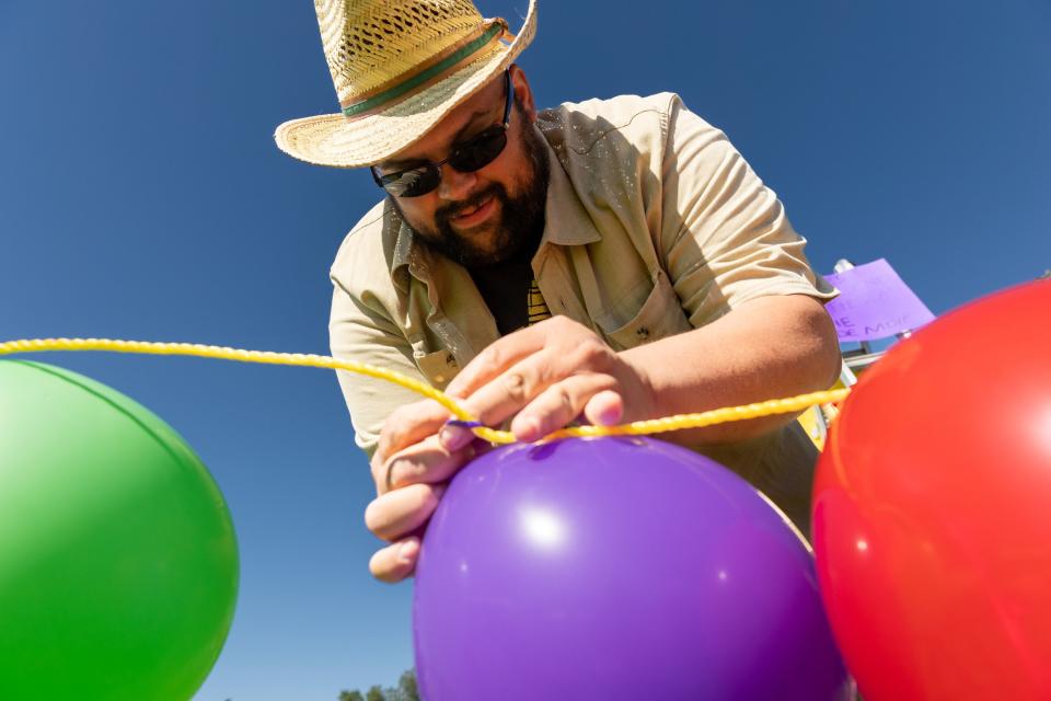 Luis Gonzalez ties balloons to a string at La Guelaguetza at Heritage Park in Kaysville on Saturday, July 22, 2023. La Guelaguetza is an event held to celebrate the rich culture and traditions of Oaxaca, Mexico. | Megan Nielsen, Deseret News