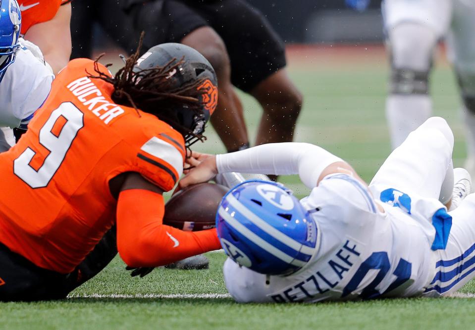 Nov 25, 2023; Stillwater, Oklahoma, USA; Oklahoma State's Trey Rucker (9) recovers a fumble from BYU's Jake Retzlaff (12) during the first half of the college football game between the Oklahoma State University Cowboys and the Brigham Young Cougars at Boone Pickens Stadium. Mandatory Credit: Sarah Phipps-USA TODAY Sports