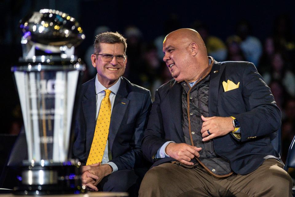 Michigan head coach Jim Harbaugh talks to athletic director Warde Manuel during the national championship celebration at Crisler Center in Ann Arbor on Saturday, Jan. 13, 2024.