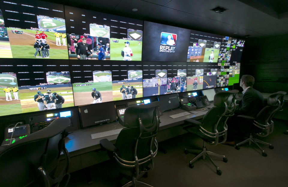 A technician works in front of a bank of television screens during a preview of Major League Baseball's Replay Operations Center, in New York, Wednesday, March 26, 2014. Less than a week before most teams open, MLB is working on the unveiling of its new instant replay system, which it hopes will vastly reduce incorrect calls by umpires. (AP Photo/Richard Drew)