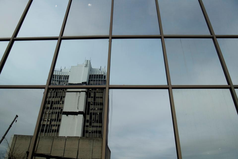 The 420 Main building is reflected in the windows of the United Fidelity Bank in Downtown Evansville Monday morning, Nov. 15, 2021. Renascent, a demolition services company, is imploding the 18-story tower at 420 Main Street this Sunday, Nov. 21, at about 7 a.m.