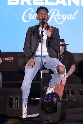 <p>Marcus Ingram/Getty</p> BRELAND performs as Crown Royal hosts NFL watch party for US Military in San Antonio, Texas on Nov. 27, 2023