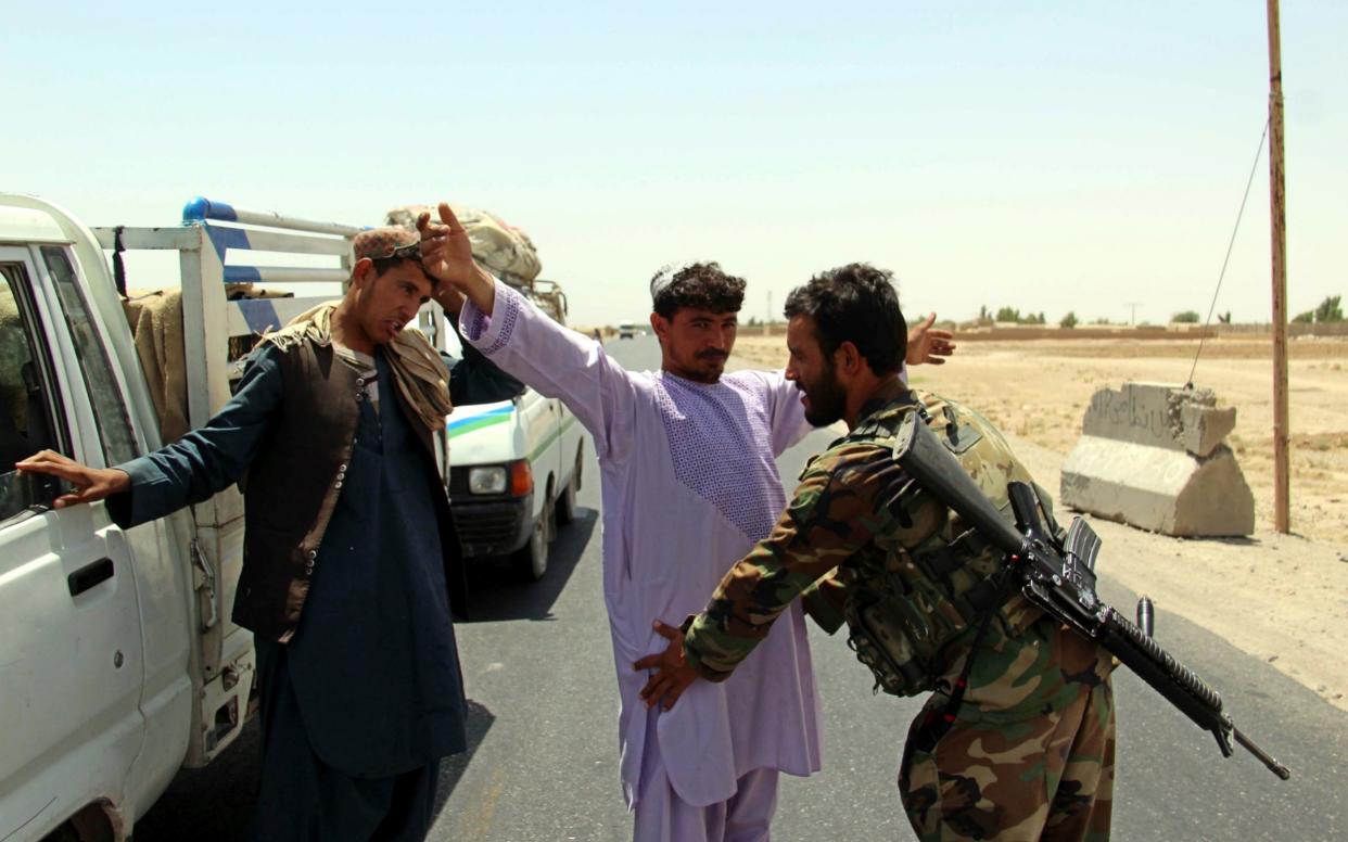 Afghan Army soldiers search people at a check point on a highway leading to the Maiwind district of restive Kandahar, Afghanistan after a Taliban attack - EPA