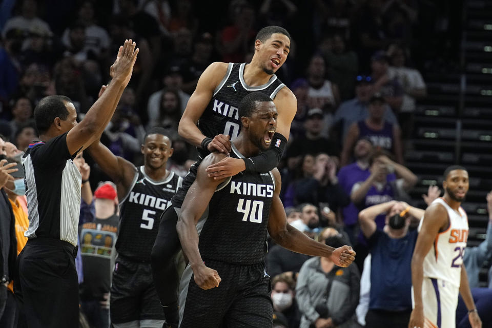 Sacramento Kings forward Harrison Barnes (40) celebrates with guard Tyrese Haliburton (0) and guard De'Aaron Fox (5) after scoring as time expired during an NBA basketball game against the Phoenix Suns, Wednesday, Oct. 27, 2021, in Phoenix. Sacramento won 110-107. (AP Photo/Rick Scuteri)