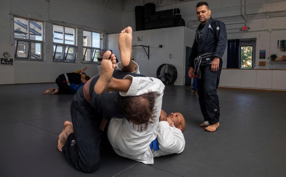 Fabio Lima, owner of 313 Brazilian Jiu Jitsu, watches his students Zach Mabey, a brown belt in Brazilian jujitsu and Josh Clowney, a blue belt, grapple during a training session inside his gym in Detroit on Wednesday, Aug. 16, 2023.