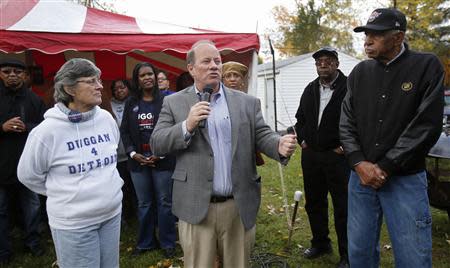 Mayoral candidate Mike Duggan (front 2nd L) addresses a crowd of supporters as his mother Joan (front L) and Detroit resident David Miller (R) listen during a campaign stop in his childhood neighborhood in Detroit, Michigan November 2, 2013. REUTERS/Rebecca Cook