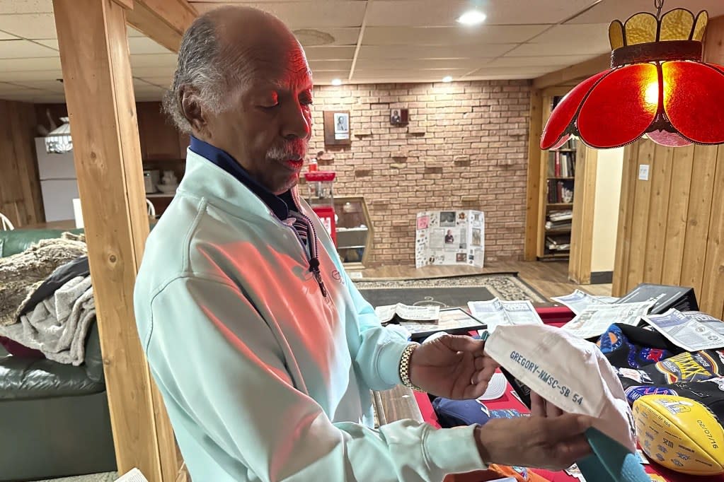 Gregory Eaton holds a commemorative Super Bowl hat with his name on it at his home, Tuesday, Jan. 30, 2024 in Lansing, Mich. (AP Photo/Mike Householder)