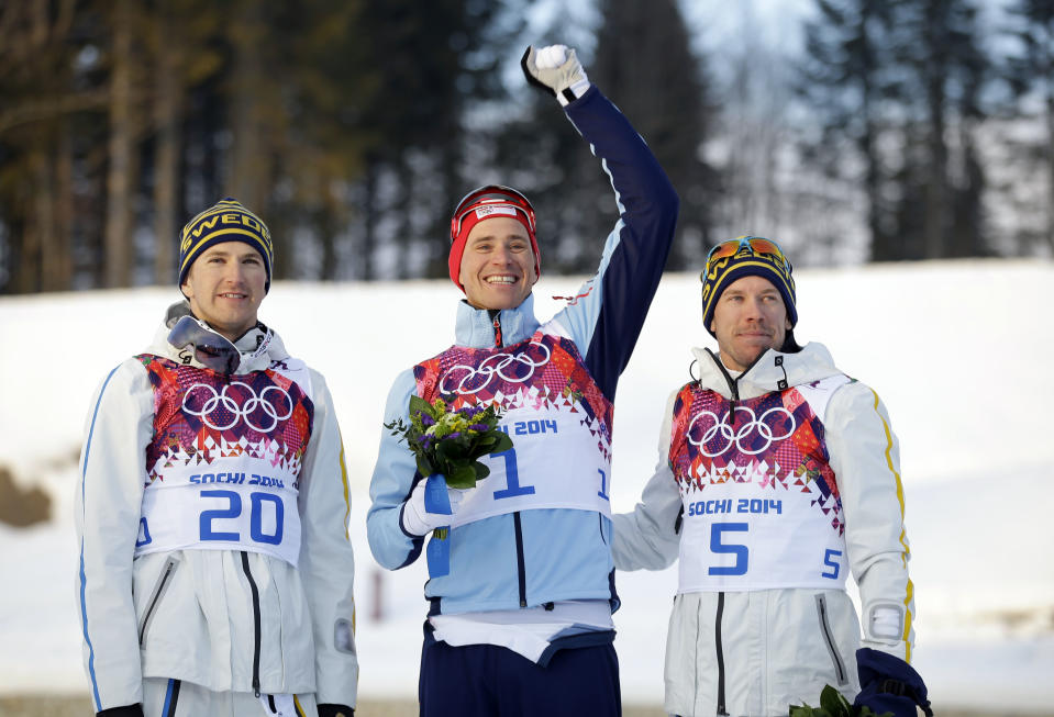 Norway's gold medal winner Ola Vigen Hattestad, center, is flanked by Sweden's silver medal winner Teodor Peterson, left, and Sweden's bronze medal winner Emil Joensson during the flower ceremony of the men's cross-country sprint final at the 2014 Winter Olympics, Tuesday, Feb. 11, 2014, in Krasnaya Polyana, Russia. (AP Photo/Gregorio Borgia)