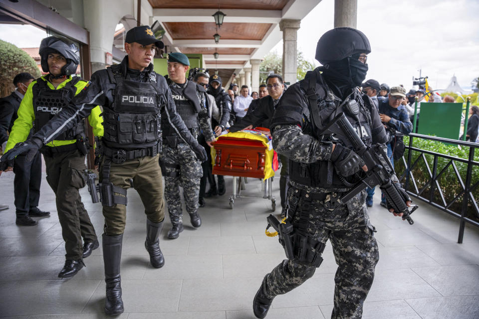 Police escort the coffin carrying the remains of slain presidential candidate Fernando Villavicencio at Camposanto Monteolivo cemetery for his burial in Quito, Ecuador, Friday, Aug. 11, 2023. The 59-year-old was fatally shot at a political rally on Aug. 9 in Quito. (AP Photo/Carlos Noriega)