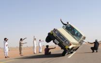 RNPS - PICTURES OF THE YEAR 2013 - Saudi youths demonstrate a stunt known as "sidewall skiing" (driving on two wheels) in the northern city of Hail, in Saudi Arabia March 30, 2013. Performing stunts such as sidewall skiing and drifts is a popular hobby amongst Saudi youths. REUTERS/Mohamed Al Hwaity (SAUDI ARABIA - Tags: SOCIETY TPX)