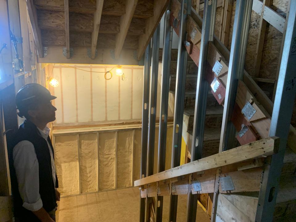 In July, Corey Heaslip, vice president of Delphi Construction, examines a staircase in the new Brewster Woods housing development in Brewster.