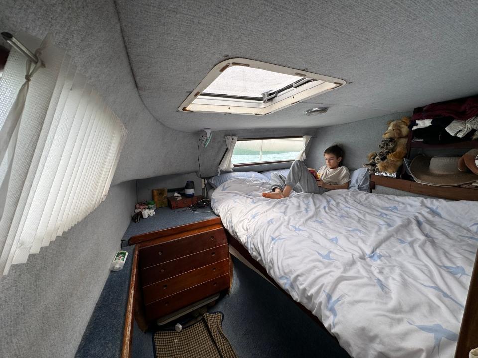 A bed underneath a skylight in a boat 