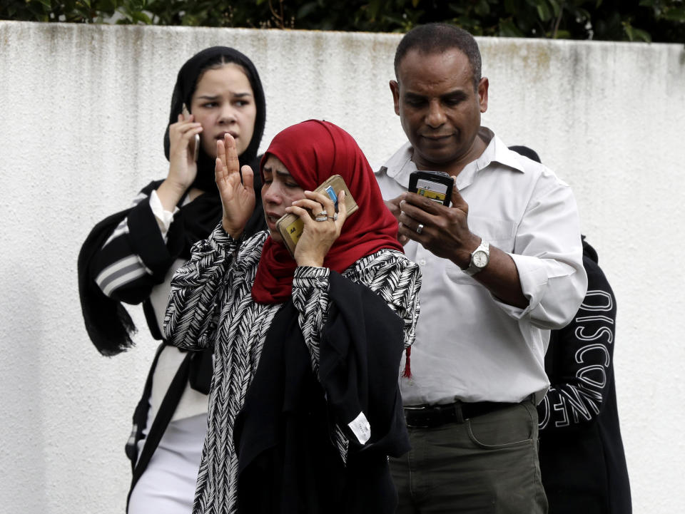 FILE - In this March 15, 2019, file photo, people wait outside a mosque in central Christchurch, New Zealand. The gunman who attacked two mosques in New Zealand, killing at least 49 people, was said to have been inspired by the man who in 2015 killed nine black worshippers at a church in Charleston, South Carolina. (AP Photo/Mark Baker, File)