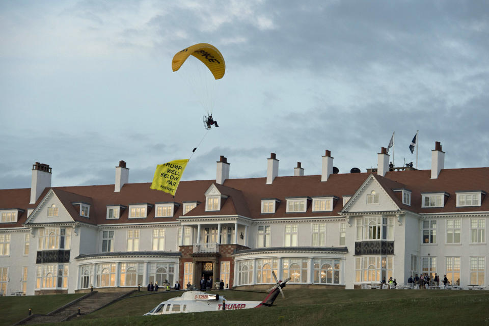 <p>A Greenpeace protester flying a microlight paraglider-style aircraft passes over President Trump’s golf resort in Turnberry, South Ayrshire, Scotland, on Friday, July 13, 2018, with a banner reading “Trump: Well Below Par,” shortly after the president arrived at the hotel. Scottish police said the protester breached a no-fly zone over Turnberry hotel and committed a criminal offense. (Photo: John Linton/PA via AP) </p>