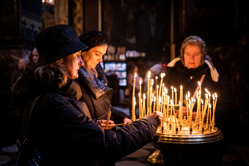 Worshippers pray and light candles in St. Volodymyr's Cathedral, the Ukrainian Orthodox Church of the Kyiv Patriarchate, on Nov. 06 in Kyiv, Ukraine. Electricity and heating outages across Ukraine caused by missile and drone strikes to energy infrastructure have added urgency preparations for winter.