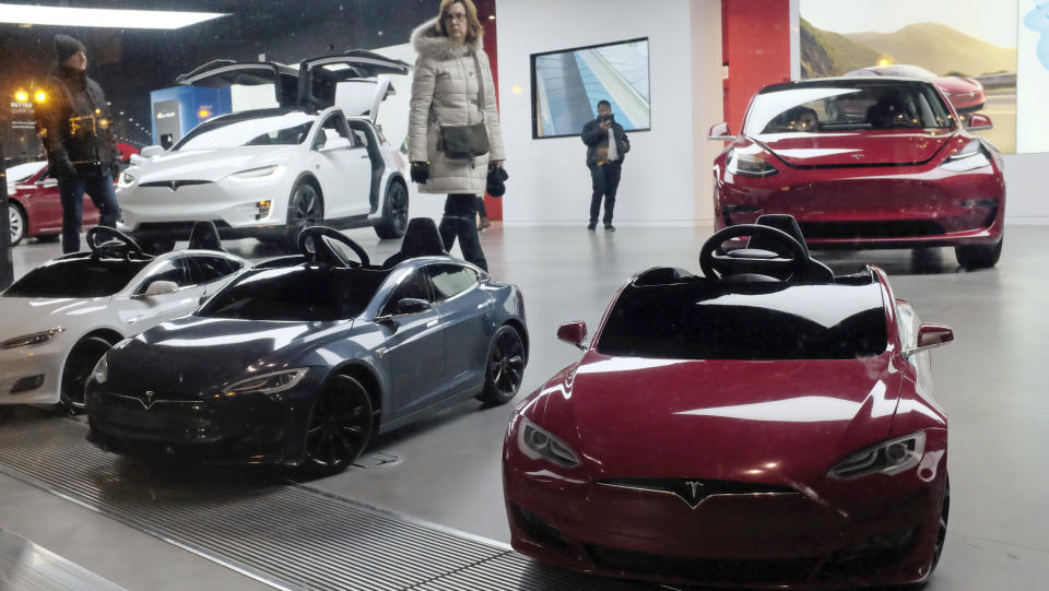 In this Nov. 10, 2018 photo, Tesla Model S, battery operated ride-on cars for children, are displayed by the front window at a Tesla showroom in downtown Chicago. (AP Photo/Kiichiro Sato)