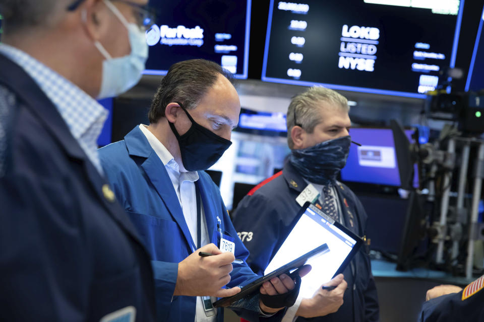 In this photo provided by the New York Stock Exchange, traders work on the floor, Thursday Dec. 3, 2020. U.S. stocks are inching further into record heights Thursday, as Wall Street continues to coast following its rocket ride last month powered by hopes for coming COVID-19 vaccines. (Nicole Pereira/New York Stock Exchange via AP)