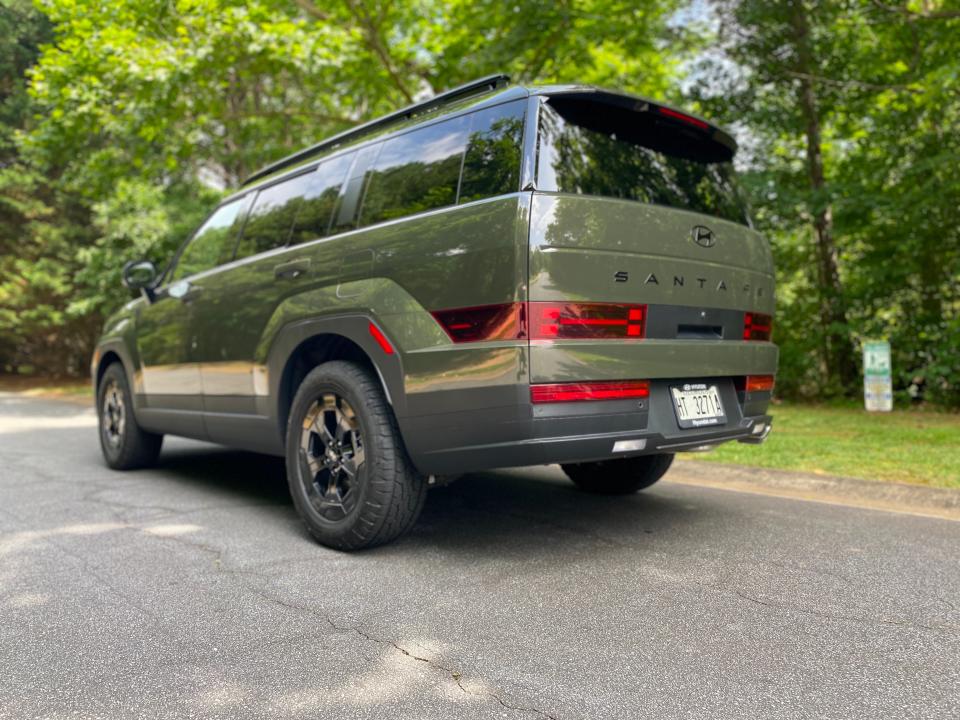 The rear three-quarters of a green 2024 Hyundai Santa Fe XRT SUV.