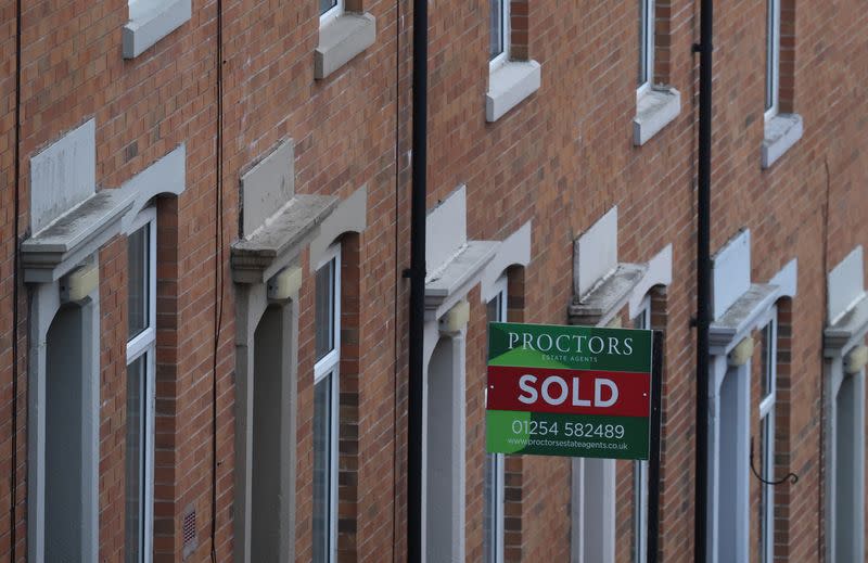 An estate agent's board is displayed outside a house on a terraced street in Blackburn