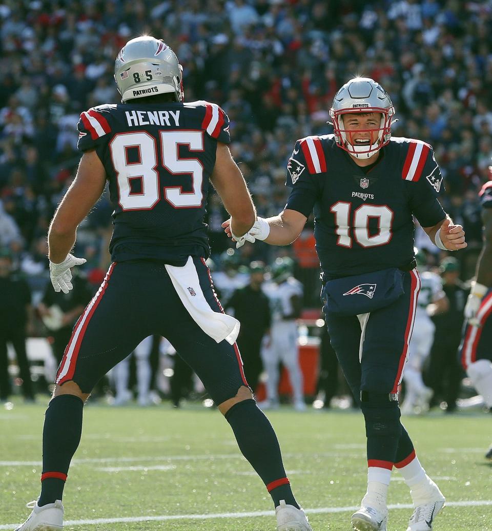 Patriots tight end Hunter Henry celebrates after catching a touchdown pass from Mac Jones, right.