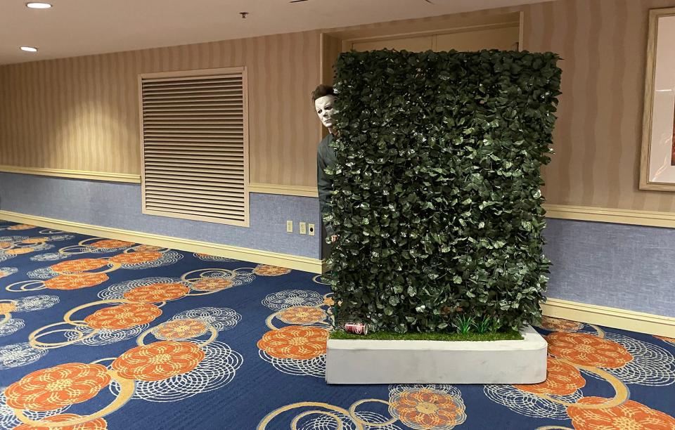 A Michael Myers cosplayer rolls their accessory hedge around an empty corridor at the Days of the Dead convention in Atlanta, Ga. on Aug. 28, 2021.