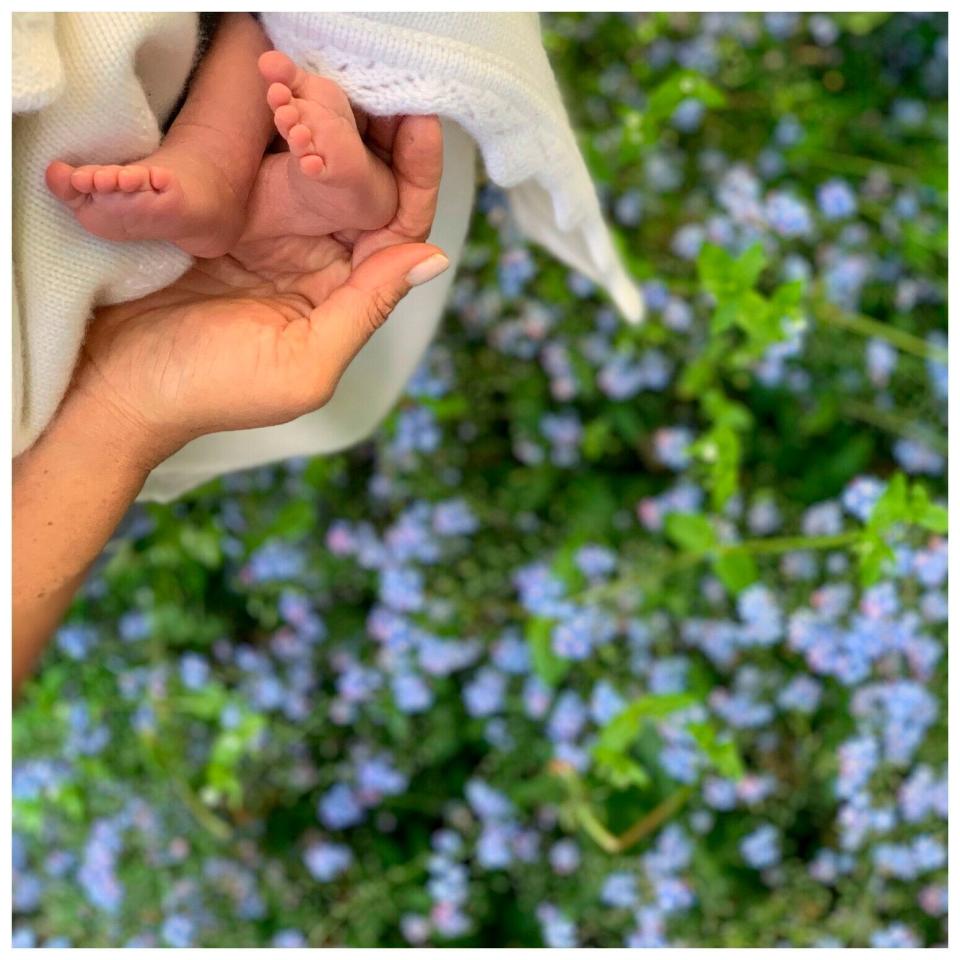 Duchess Meghan of Sussex cradles the feet of her baby, Archie Harrison Mountbatten-Windsor, in an image posted on their Instagram page to mark her first Mother's Day as a mom.