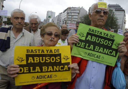 People hold placardds reading "Enough with Bank abuses" during a demonstration June 2, in Coruna. Spain's weak banks need at least 40 billion euros (US$50 billion) in new capital to strengthen against severe financial shocks, the International Monetary Fund said
