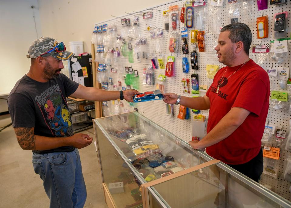Julian Conde (left), of Winter Park, talks about racing while looking at car bodies with Joe Milstead, owner of Slot Car Raceway and Hobby Shop on Sunday, June 11, 2023, in Vero Beach. "I race pretty much everything, RC (radio controlled) boats, cars, slot cars and planes and turbine jets, and rockets. I do rockets as well,"  Conde, said. "I normally bring my little one here every other weekend so when I have my little one I always come here. We're here the minute it opens to right around closing time. Family fun, something I can do with my son."