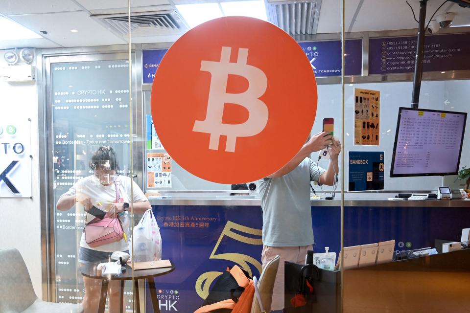 This photo taken on May 27, 2023 shows customers in a cryptocurrency exchange office in Hong Kong. Retail investors in Hong Kong may soon be able to buy popular cryptocurrencies like bitcoin at government-licensed exchanges, thanks to new rules meant to bolster the city's standing as a digital asset hub. (Photo by Peter PARKS / AFP) / TO GO WITH HongKong-China-economy-Cryptocurrency,FOCUS by Holmes CHAN (Photo by PETER PARKS/AFP via Getty Images)