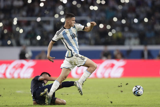 Argentina's Valentin Carboni, center, is fouled by Guatemala's Carlos Santos during a FIFA U-20 World Cup Group A soccer match at the Madre De Ciudades stadium in Santiago del Estero, Argentina, Tuesday, May 23, 2023. (AP Photo/Nicolas Aguilera)