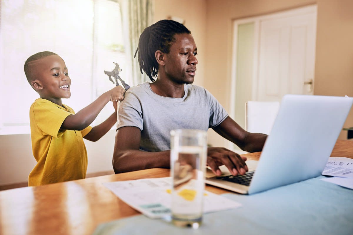 A father works from home with his child bothering him.