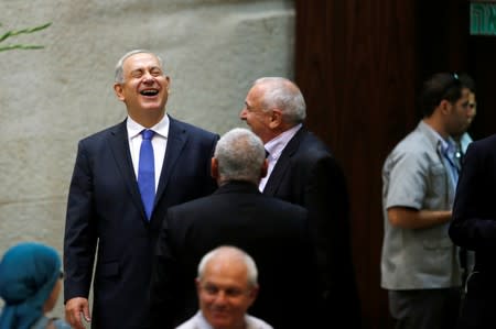 FILE PHOTO: Israel's PM Netanyahu laughs upon his arrival to the opening of the winter session of the Knesset, the Israeli parliament, in Jerusalem