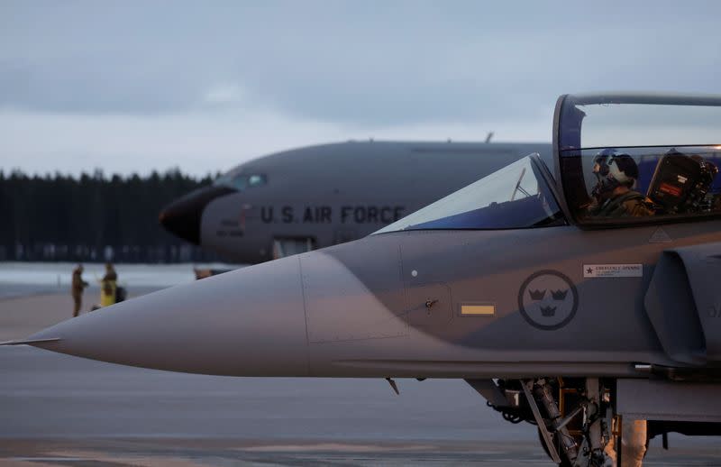 A Swedish JAS Gripen fighter jet stands next to an U.S. plane at Kallax Air Base