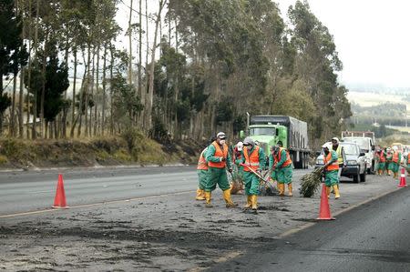 Workers sweep the road to remove ash spewed by the Cotopaxi volcano in Chasqui, Ecuador, August 14, 2015. REUTERS/Guillermo Granja