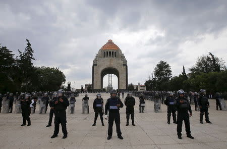 Police officers stand guard as members of the teacher's union CNTE (not pictured) march past the Revolution Monument in Mexico City June 1, 2015. REUTERS/Henry Romero