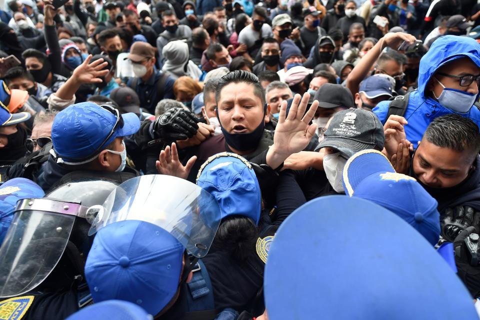 Policías de Ciudad de México contienen a cientos de sus colegas afuera de la sede del gobierno de la capital donde protestaban por salarios no pagados Foto: ALFREDO ESTRELLA/AFP via Getty Images